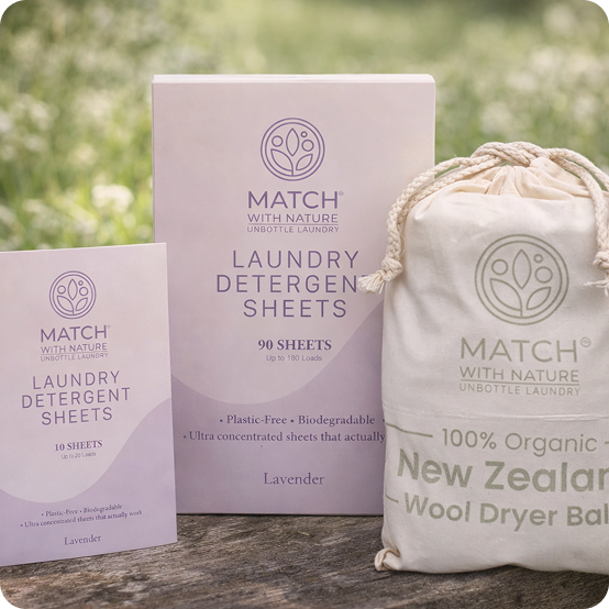 Match with Nature laundry detergent sheets and wool dryer ball on a wooden surface with a blurred natural background.