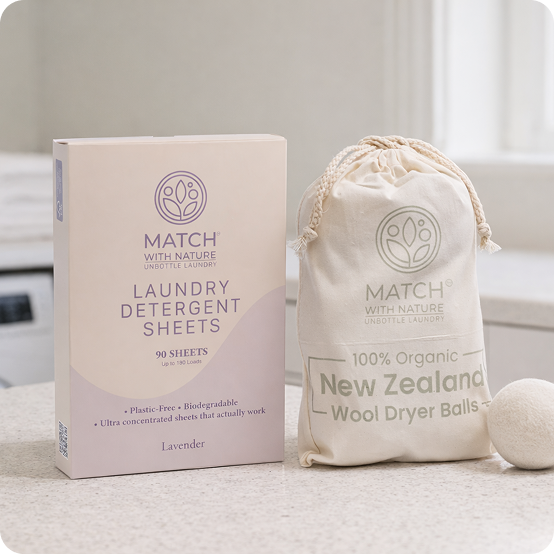 Match with Nature laundry detergent sheets packaging and organic wool dryer balls on a neutral background