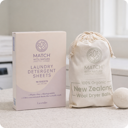 Match with Nature laundry detergent sheets packaging and organic wool dryer balls on a neutral background