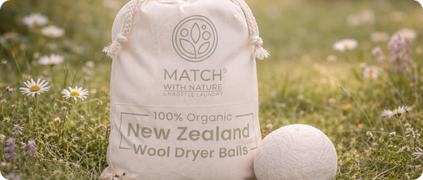 Bag of New Zealand wool dryer balls with branding in a grassy field.